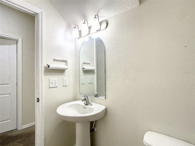 bathroom featuring a textured ceiling and toilet