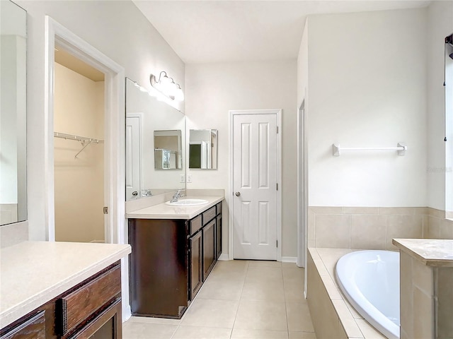 bathroom featuring vanity, tile patterned floors, and tiled tub