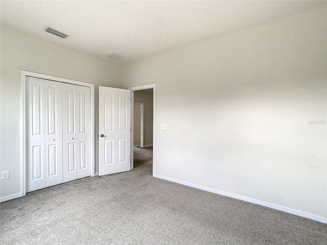 unfurnished bedroom featuring carpet flooring and a closet