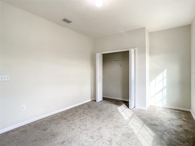 unfurnished bedroom with a closet and light colored carpet