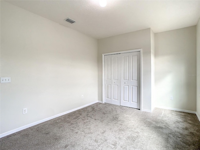 unfurnished bedroom featuring carpet floors and a closet