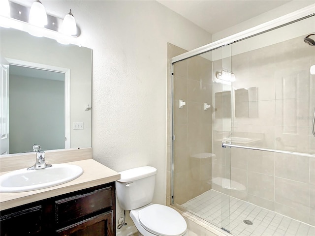 bathroom with vanity, toilet, and a shower with shower door