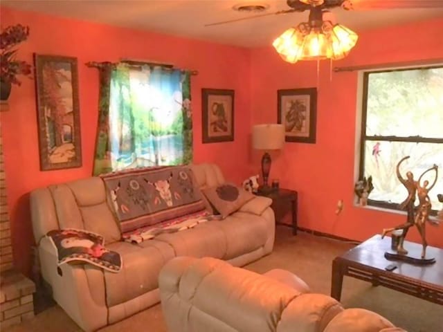 living room with plenty of natural light, ceiling fan, and light colored carpet