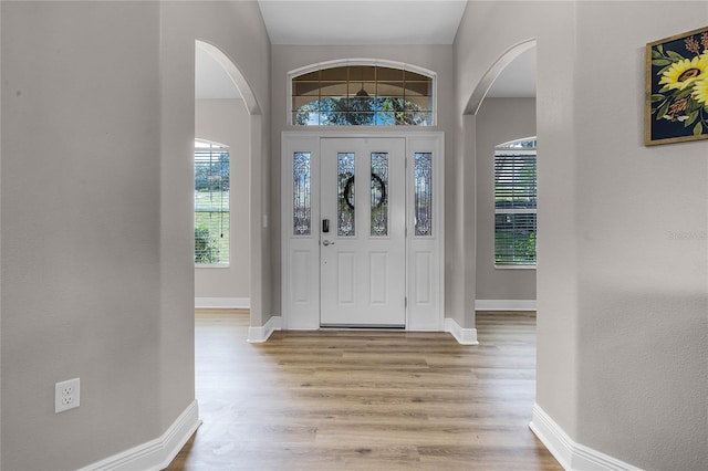 10120 Lakeshore Dr, Clermont, FL 34711 - foyer entrance featuring arched walkways and light wood-style floors