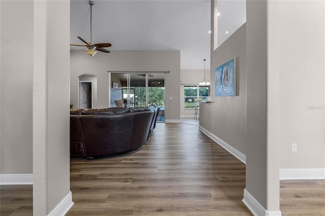 10120 Lakeshore Dr, Clermont, FL 34711 - living room featuring ceiling fan, arched walkways, wood finished floors, and a high ceiling