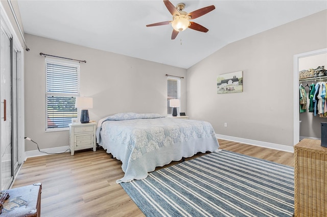 10120 Lakeshore Dr, Clermont, FL 34711 - bedroom featuring light wood-style floors, a closet, lofted ceiling, a ceiling fan, and a walk in closet