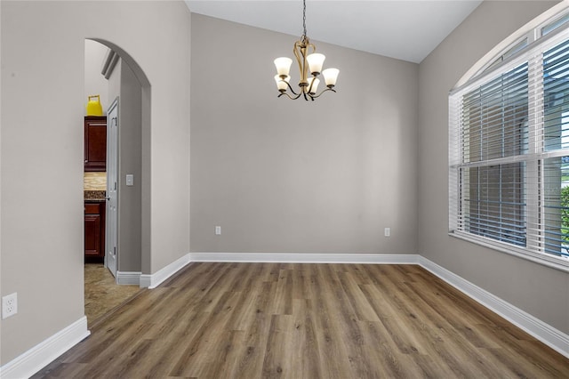 10120 Lakeshore Dr, Clermont, FL 34711 - unfurnished room featuring arched walkways, wood finished floors, and a chandelier