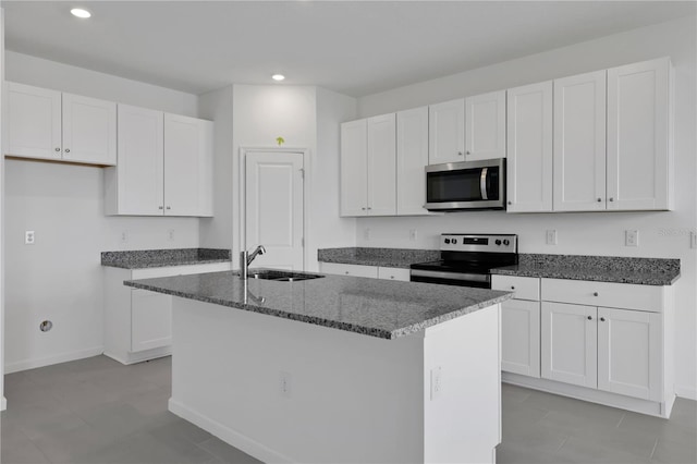 kitchen with a kitchen island with sink, white cabinetry, sink, and stainless steel appliances