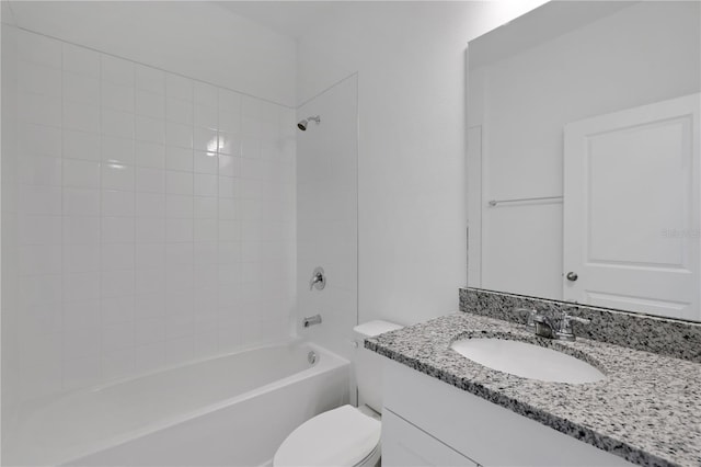 full bathroom with tiled shower / bath, vanity, and toilet