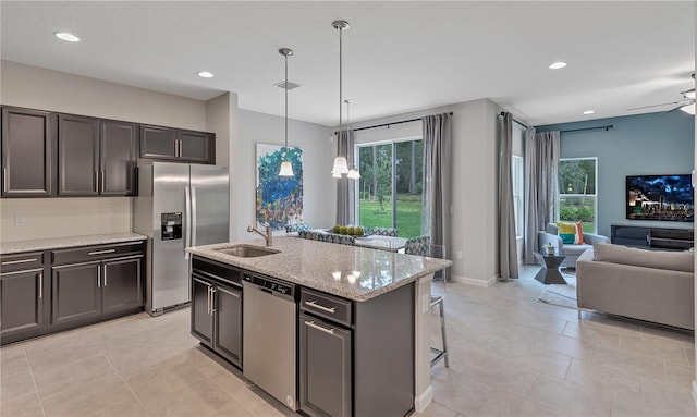 kitchen featuring plenty of natural light, a center island with sink, stainless steel appliances, and ceiling fan