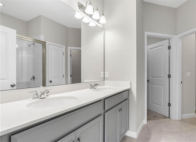 bathroom with walk in shower, oversized vanity, tile floors, and dual sinks