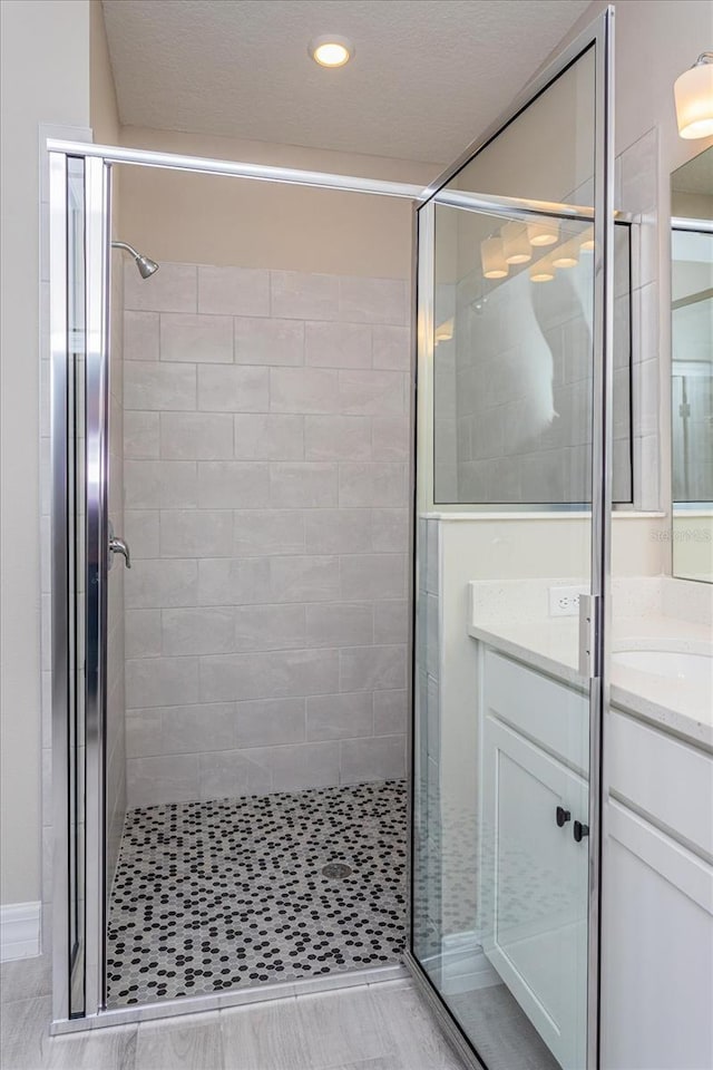 bathroom with a shower with door, tile floors, and oversized vanity