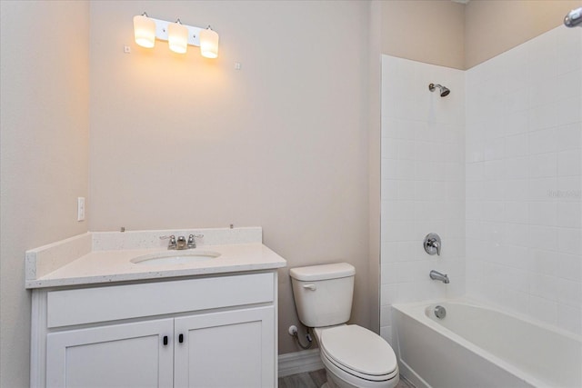 full bathroom featuring vanity, tiled shower / bath combo, and toilet