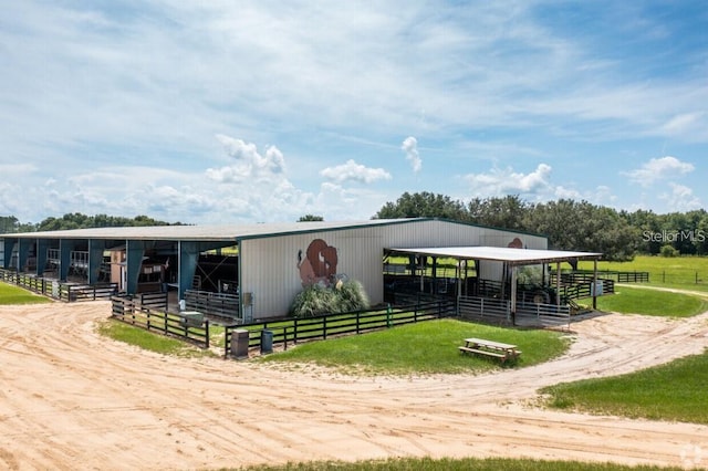 view of horse barn with a rural view and an outbuilding