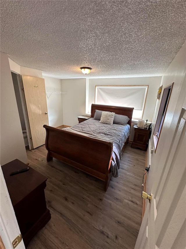 bedroom featuring a textured ceiling and wood-type flooring