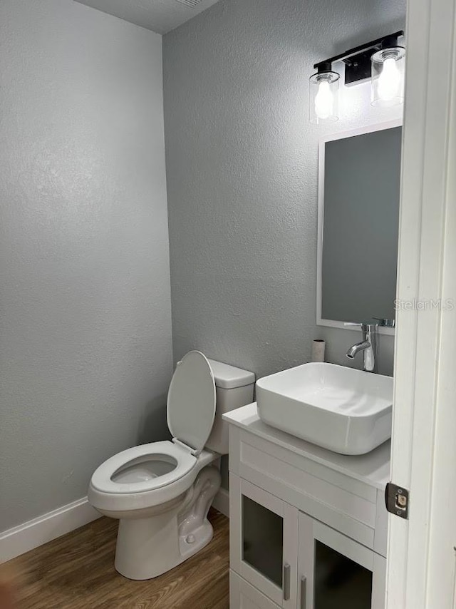 bathroom with vanity, wood-type flooring, and toilet