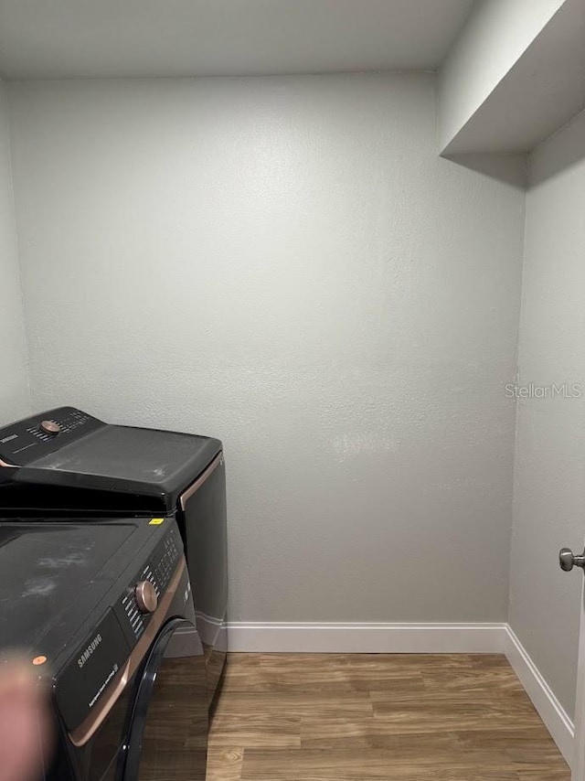 laundry room with washer and dryer and light hardwood / wood-style flooring