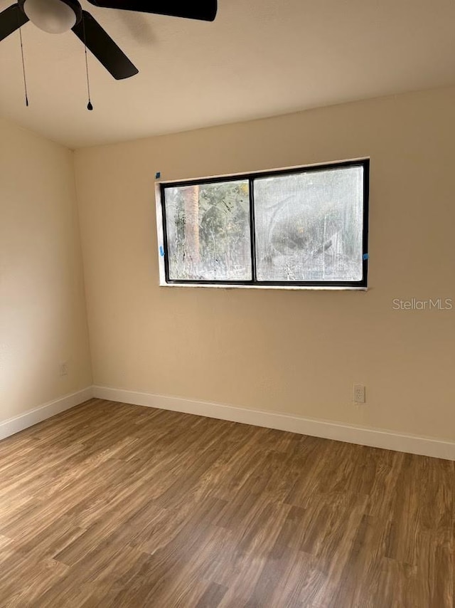 empty room with ceiling fan and light hardwood / wood-style flooring