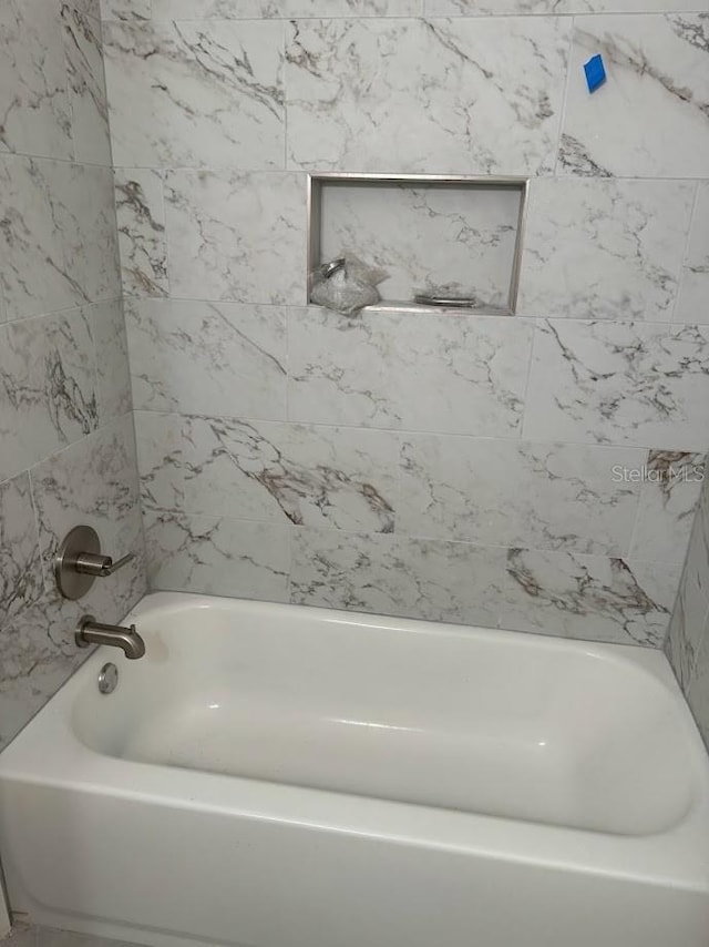 bathroom featuring tiled shower / bath