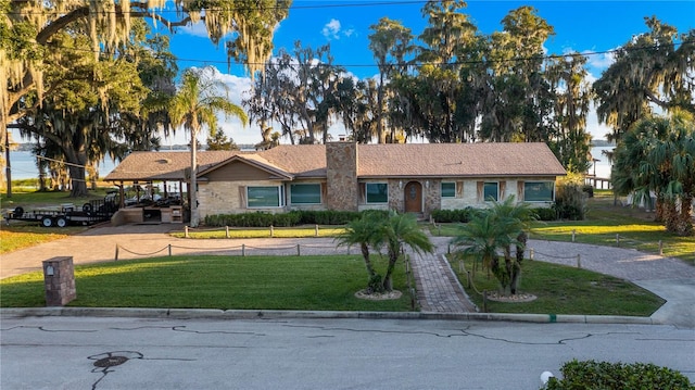 ranch-style home with a carport and a front lawn