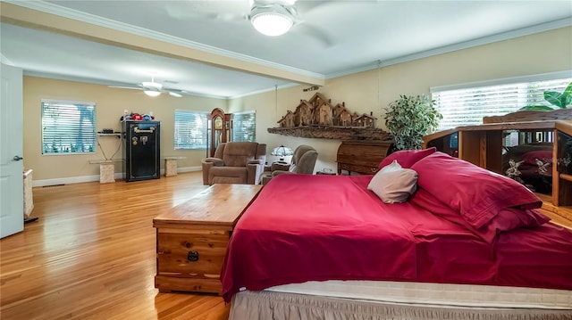 bedroom with hardwood / wood-style flooring, ceiling fan, ornamental molding, and multiple windows