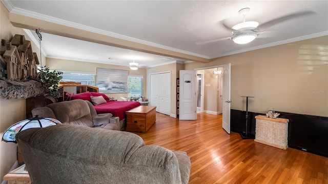 living room with hardwood / wood-style flooring, crown molding, and ceiling fan