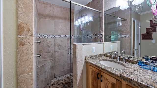 bathroom featuring ornamental molding, vanity, and an enclosed shower