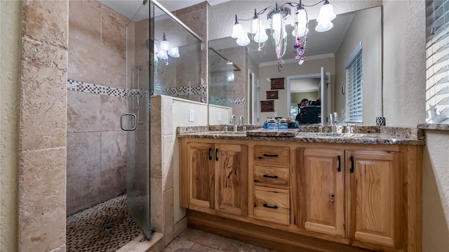 bathroom featuring a chandelier, ornamental molding, an enclosed shower, and vanity