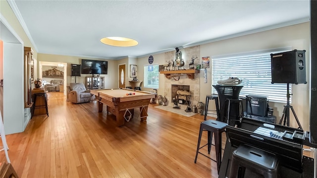 rec room with pool table, ornamental molding, a fireplace, and hardwood / wood-style floors