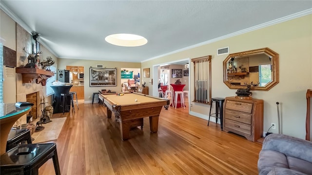 rec room featuring ornamental molding, light hardwood / wood-style flooring, billiards, and a fireplace