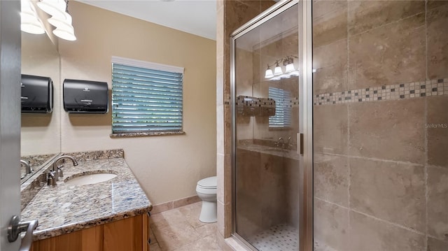 bathroom featuring tile patterned floors, vanity, toilet, and a shower with shower door