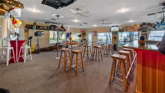 dining space featuring ceiling fan and a textured ceiling