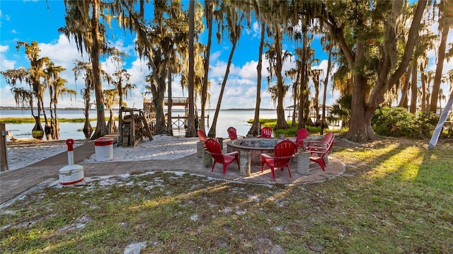 view of patio with a water view and an outdoor fire pit