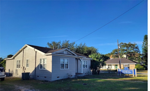 exterior space featuring a front lawn and central AC