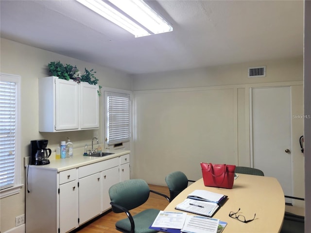 office space featuring a baseboard radiator, sink, and light hardwood / wood-style flooring