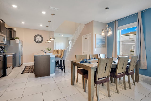 tiled dining room with sink and an inviting chandelier