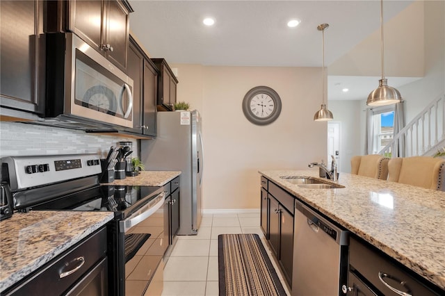 kitchen featuring pendant lighting, sink, appliances with stainless steel finishes, light tile patterned floors, and dark brown cabinets