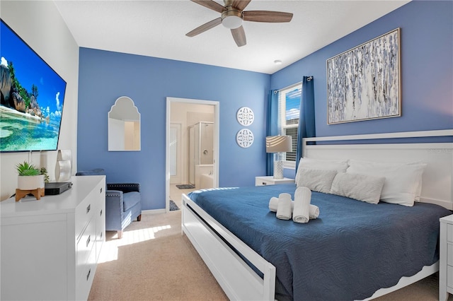 bedroom featuring ceiling fan, light carpet, and ensuite bath