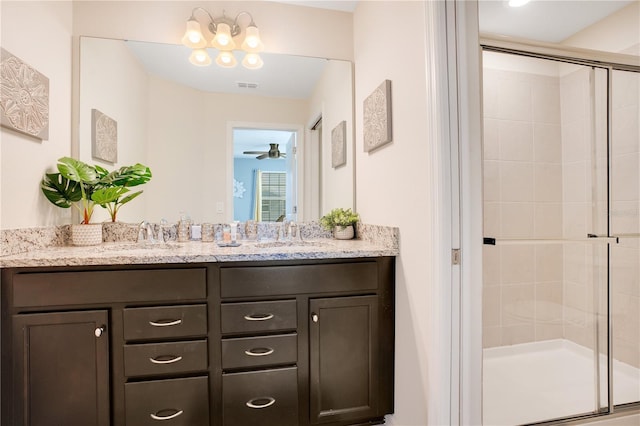 bathroom with ceiling fan with notable chandelier, vanity, and a shower with shower door