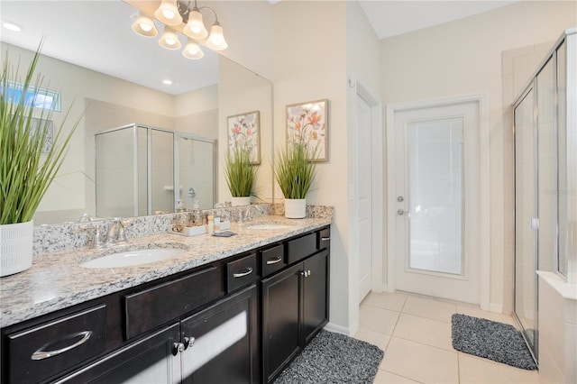 bathroom with walk in shower, vanity, a notable chandelier, and tile patterned floors