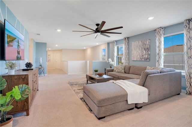 carpeted living room with ceiling fan