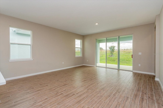 unfurnished room with recessed lighting, light wood-style flooring, and baseboards