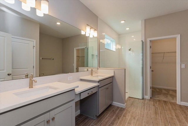 bathroom featuring a shower with shower door and double vanity