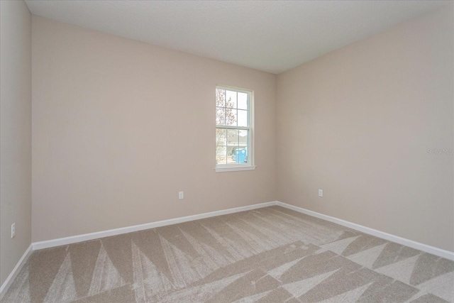 carpeted empty room with baseboards