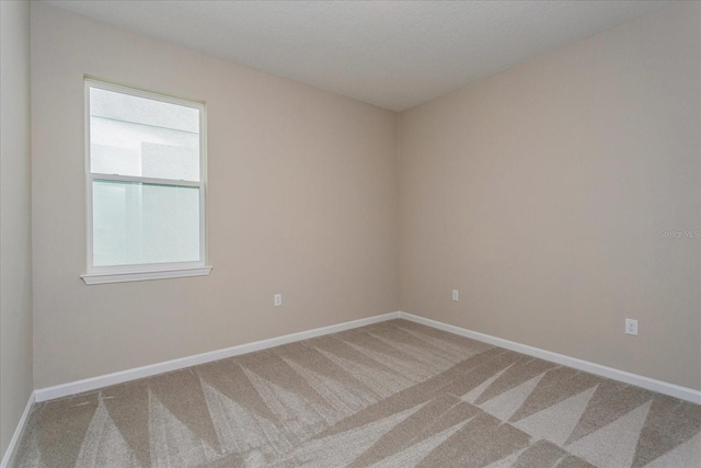 spare room featuring stairway, carpet, and baseboards