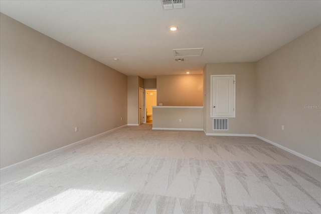 empty room featuring visible vents, light carpet, and baseboards