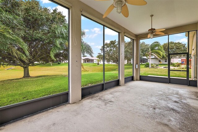 unfurnished sunroom featuring ceiling fan and a wealth of natural light