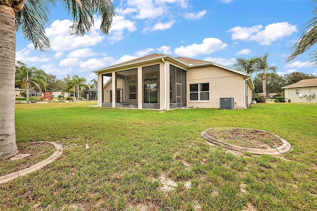 back of house with central AC unit, a sunroom, and a lawn