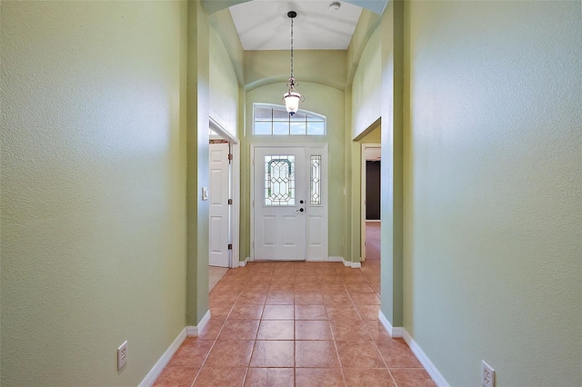 entryway featuring a towering ceiling and light tile patterned floors