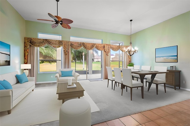 dining space featuring ceiling fan with notable chandelier, carpet floors, and a wealth of natural light